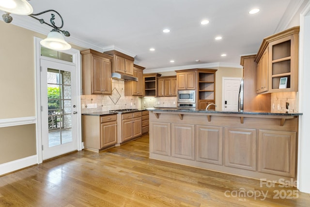 kitchen with a kitchen breakfast bar, appliances with stainless steel finishes, open shelves, a peninsula, and ornamental molding