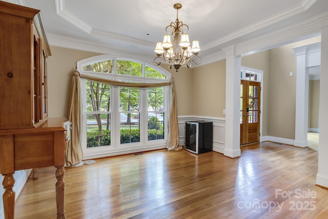 unfurnished living room featuring crown molding, plenty of natural light, french doors, and light wood-style floors