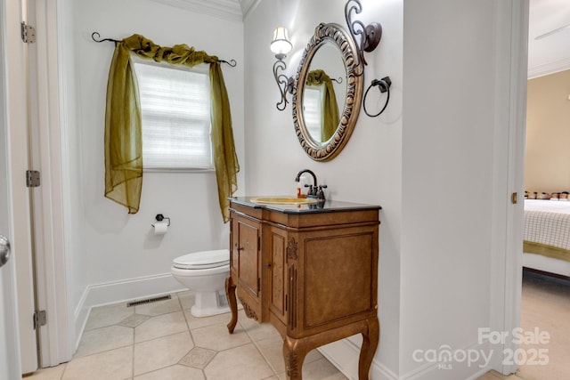 ensuite bathroom featuring crown molding, baseboards, vanity, tile patterned floors, and ensuite bathroom
