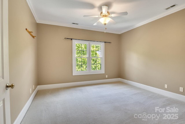 empty room with crown molding, visible vents, a ceiling fan, and light colored carpet