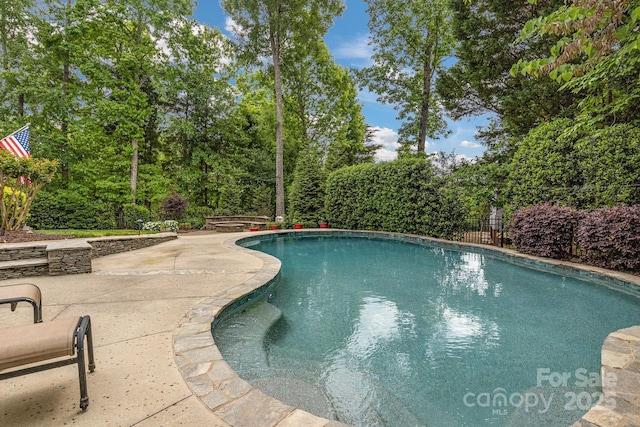 view of swimming pool with a patio, a fenced in pool, and fence