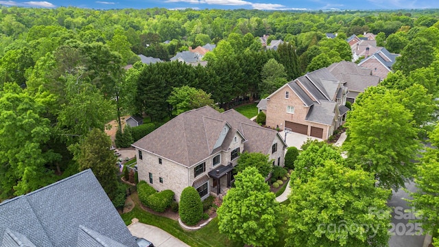 drone / aerial view featuring a residential view and a view of trees