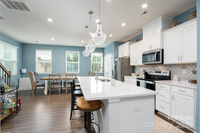 2932 Pirates Pl, Charlotte, NC 28216 - kitchen featuring stainless steel appliances, a sink, a kitchen island with sink, dark wood-style flooring, and tasteful backsplash