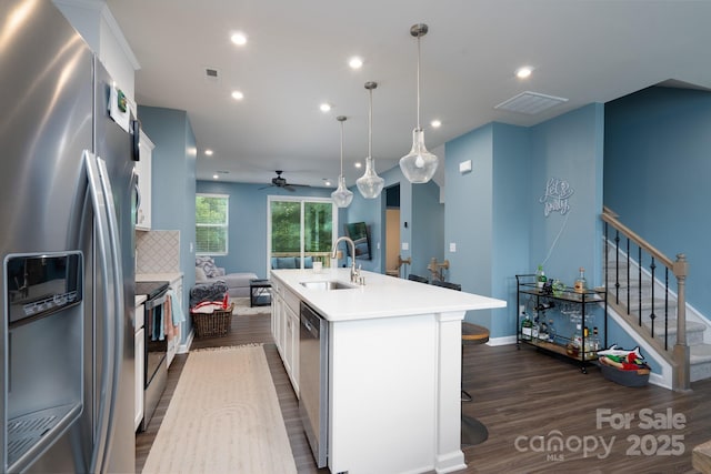 2932 Pirates Pl, Charlotte, NC 28216 - kitchen featuring stainless steel appliances, a sink, dark wood-style flooring, a center island with sink, and a ceiling fan