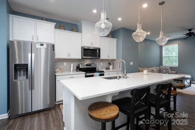 2932 Pirates Pl, Charlotte, NC 28216 - kitchen featuring appliances with stainless steel finishes, a sink, dark wood-style floors, backsplash, and open floor plan