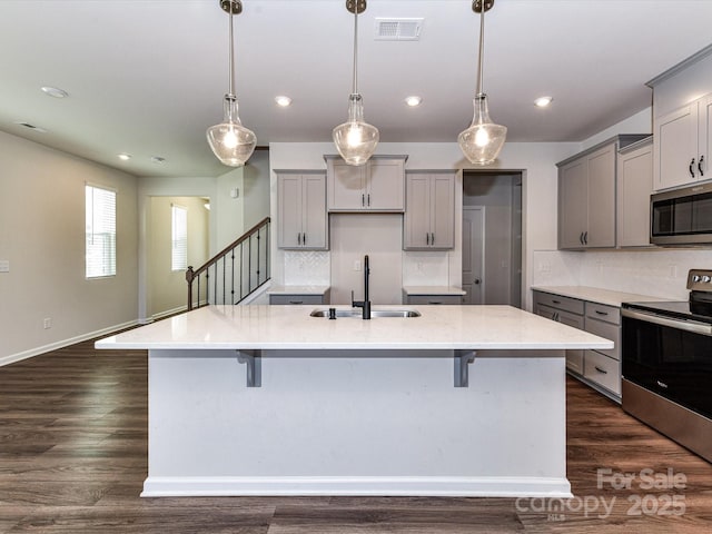 9134 Northfield Crossing Dr, Charlotte, NC 28269 - kitchen featuring gray cabinets, visible vents, appliances with stainless steel finishes, a large island with sink, and a sink