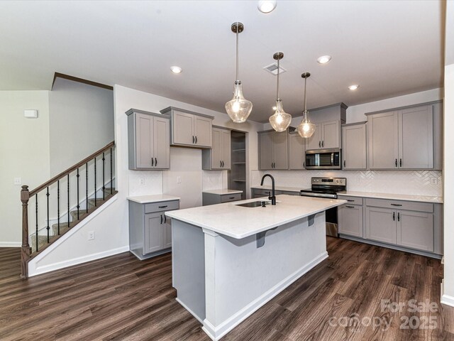9134 Northfield Crossing Dr, Charlotte, NC 28269 - kitchen with gray cabinetry, appliances with stainless steel finishes, dark wood finished floors, and a sink