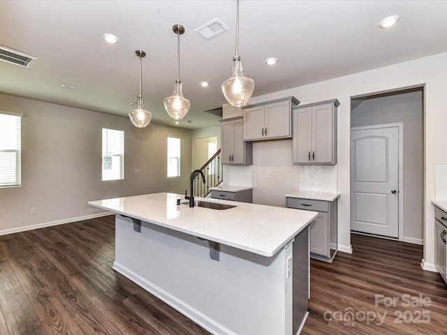 9134 Northfield Crossing Dr, Charlotte, NC 28269 - kitchen featuring visible vents, dark wood finished floors, a sink, gray cabinetry, and an island with sink