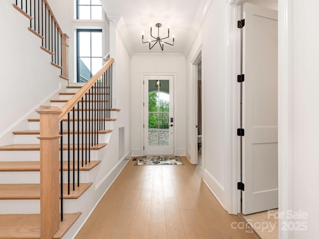 entrance foyer with visible vents, a chandelier, wood finished floors, and stairs