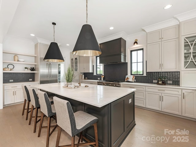 kitchen featuring stove, open shelves, custom range hood, decorative backsplash, and stainless steel built in fridge