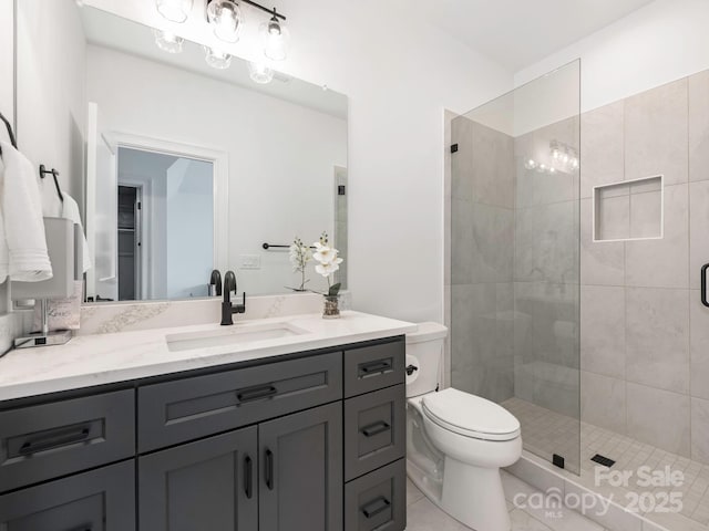 bathroom featuring toilet, a stall shower, vanity, and tile patterned flooring