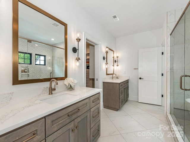 bathroom with a sink, marble finish floor, and a stall shower