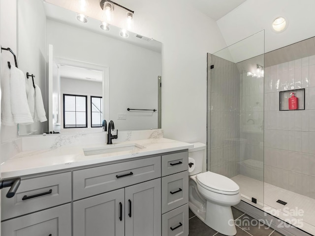 bathroom with visible vents, toilet, a walk in shower, vanity, and tile patterned flooring