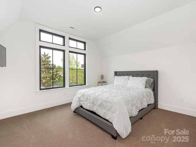 bedroom with baseboards, lofted ceiling, visible vents, and carpet floors