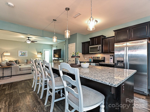 kitchen featuring visible vents, open floor plan, appliances with stainless steel finishes, and dark wood finished floors