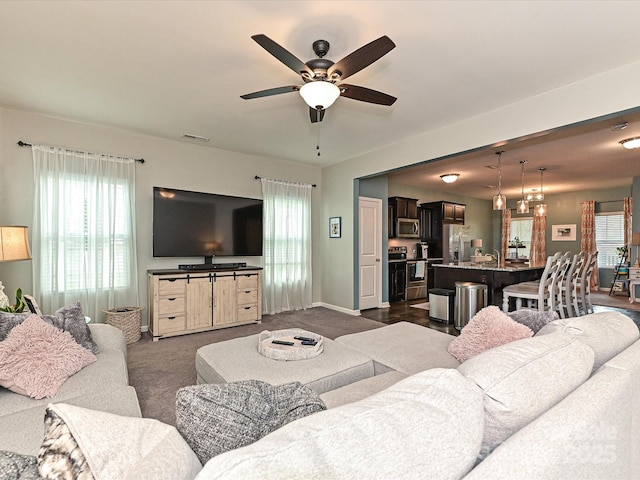 living area with plenty of natural light, visible vents, and a ceiling fan