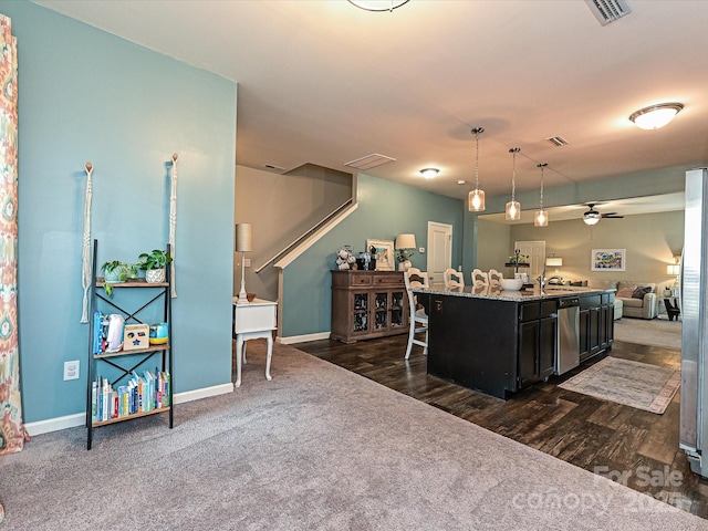 kitchen with open floor plan, a ceiling fan, visible vents, dark carpet, and hanging light fixtures