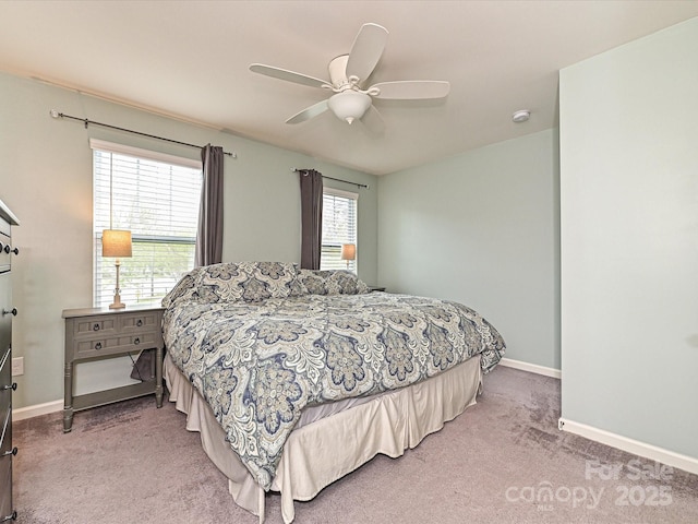 bedroom featuring multiple windows, light colored carpet, and baseboards