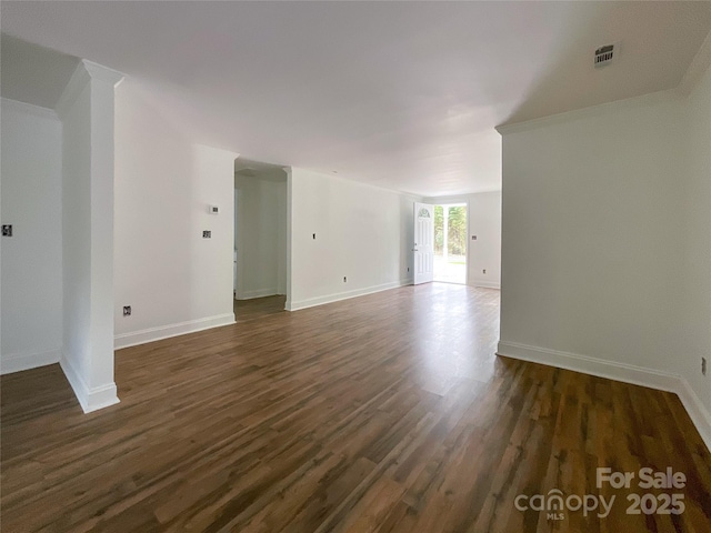 spare room with dark wood-style flooring, baseboards, and visible vents