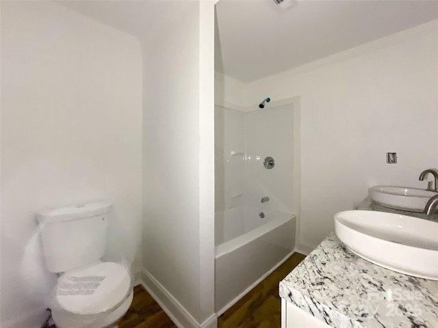 full bath with a sink, toilet, double vanity, and wood finished floors