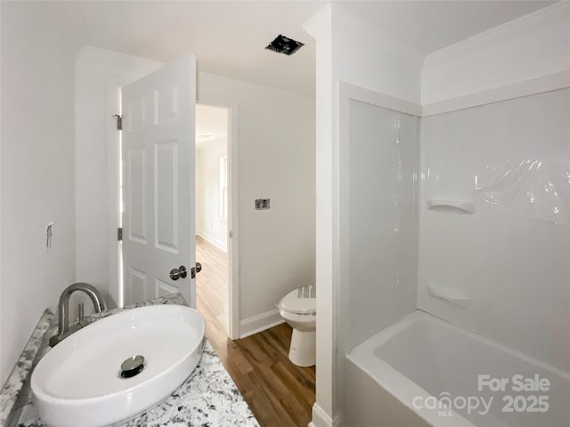 full bathroom with toilet, wood finished floors, and tub / shower combination