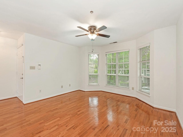 empty room with light wood-type flooring, visible vents, baseboards, and ceiling fan