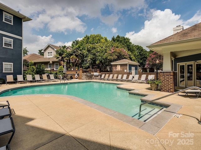 community pool with french doors, a patio area, and fence