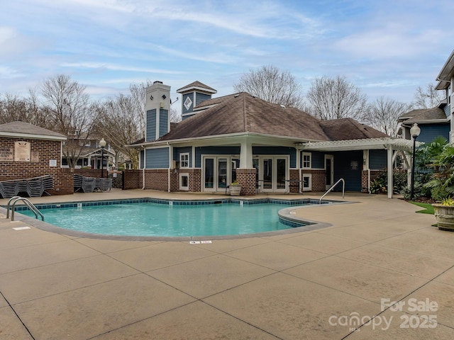 community pool with a patio, french doors, and a pergola
