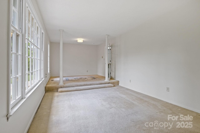 carpeted empty room featuring baseboards
