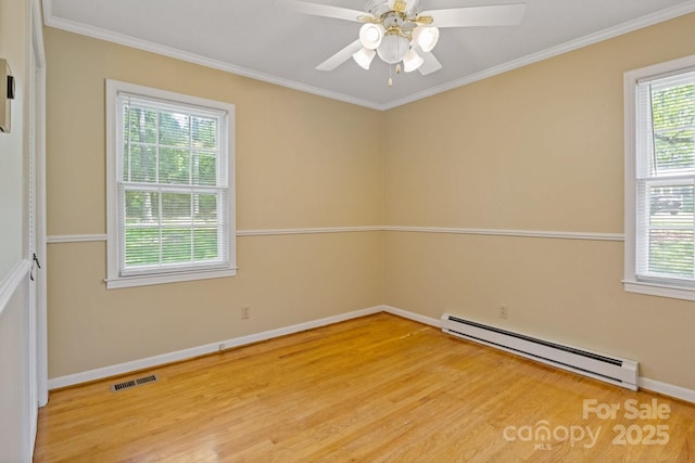 empty room featuring light wood-style flooring, visible vents, a baseboard radiator, and plenty of natural light