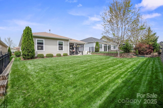 back of property with a fenced backyard, a patio, a lawn, and roof with shingles