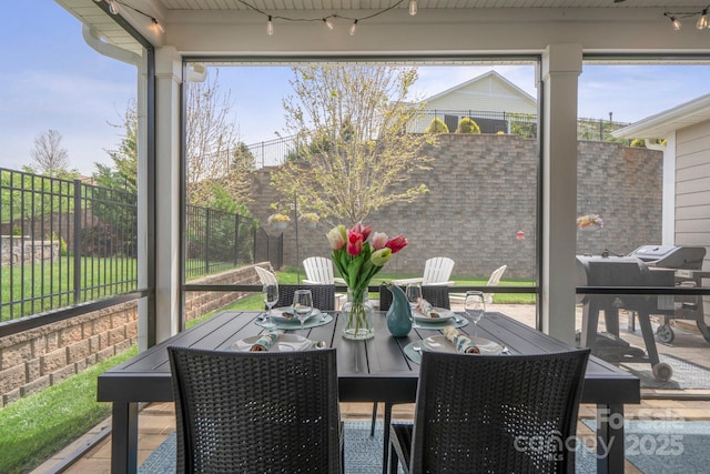 sunroom / solarium featuring outdoor dining area and plenty of natural light