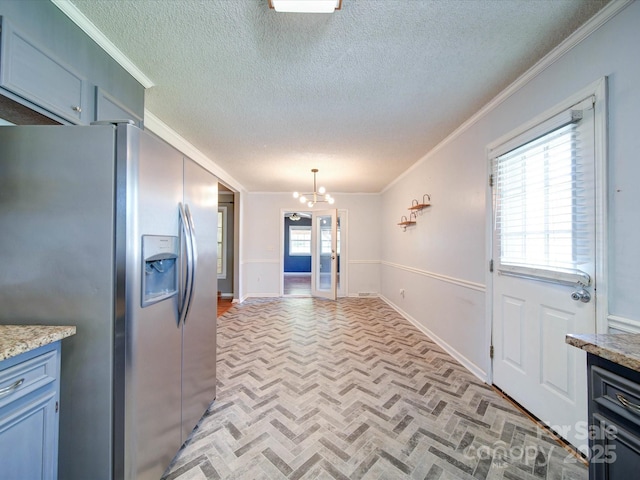 3530 Farm Lake Dr SW, Concord, NC 28027 - kitchen with stainless steel fridge with ice dispenser, a textured ceiling, ornamental molding, brick floor, and a notable chandelier