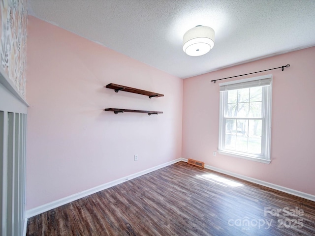 3530 Farm Lake Dr SW, Concord, NC 28027 - spare room featuring dark wood-style flooring, visible vents, baseboards, and a textured ceiling