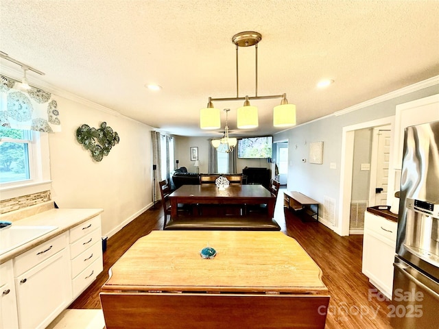 dining area with dark wood-style flooring, baseboards, ornamental molding, recessed lighting, and a textured ceiling