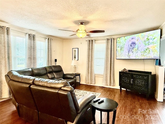 living room featuring ceiling fan, a textured ceiling, and wood finished floors