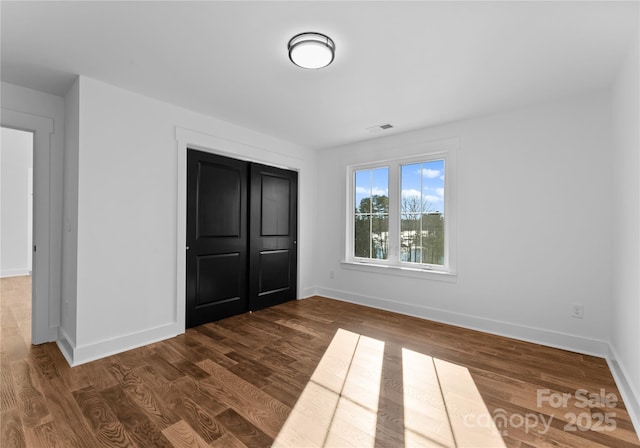 13453 Portside Ln, Lancaster, SC 29720 - unfurnished bedroom featuring visible vents, baseboards, dark wood-style floors, and a closet