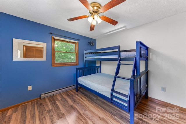 bedroom with baseboards, ceiling fan, wood finished floors, and a baseboard radiator