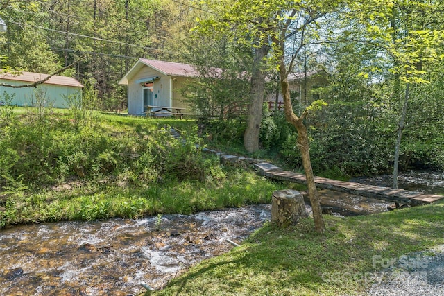 view of yard with an outbuilding and a forest view