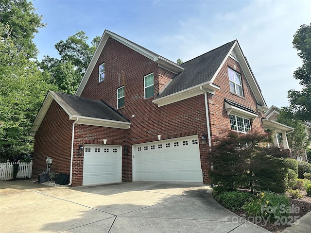 4711 Pearmain Dr, Waxhaw, NC 28173 - view of side of home with a garage, brick siding, driveway, and roof with shingles