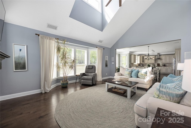 12942 Blakemore Ave, Huntersville, NC 28078 - living area featuring dark wood-style floors, visible vents, baseboards, high vaulted ceiling, and a notable chandelier