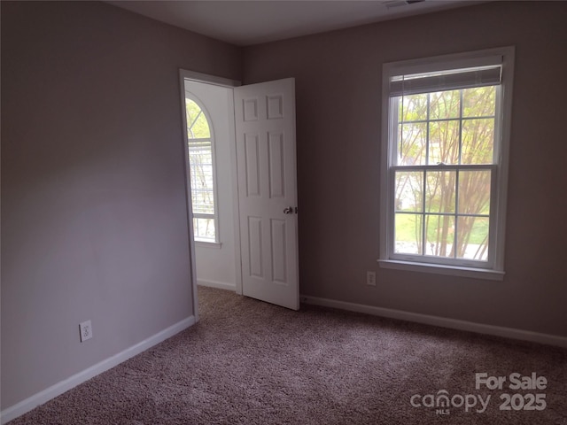 carpeted empty room featuring visible vents and baseboards