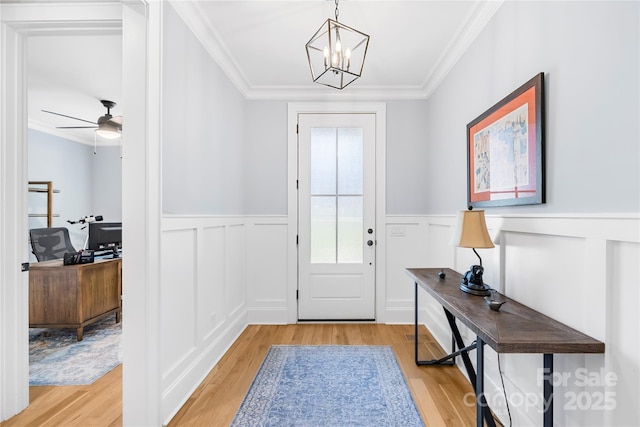 108 Castleview Ln, Mooresville, NC 28115 - doorway with wainscoting, ornamental molding, ceiling fan with notable chandelier, and light wood-type flooring