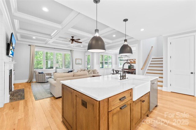 108 Castleview Ln, Mooresville, NC 28115 - kitchen with light wood finished floors, a kitchen island with sink, stainless steel dishwasher, a sink, and pendant lighting
