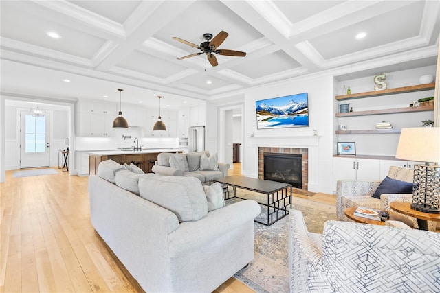 108 Castleview Ln, Mooresville, NC 28115 - living area with beamed ceiling, light wood-style floors, a brick fireplace, and a ceiling fan