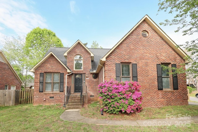 view of front of house with crawl space, fence, a front lawn, brick siding, and a shingled roof