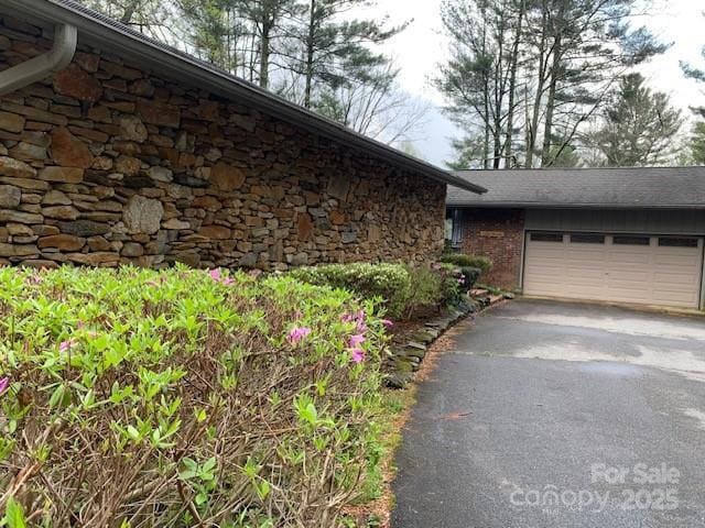 101 Lakemont Dr, Flat Rock, NC 28731 - view of property exterior featuring aphalt driveway, stone siding, and an attached garage