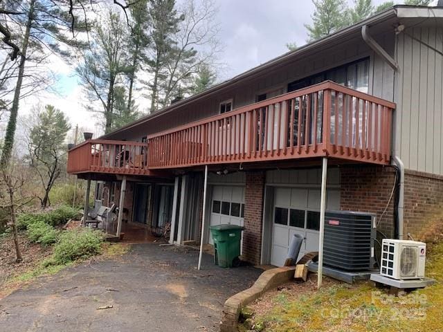 101 Lakemont Dr, Flat Rock, NC 28731 - back of property with cooling unit, aphalt driveway, brick siding, a garage, and ac unit