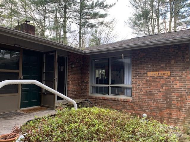 101 Lakemont Dr, Flat Rock, NC 28731 - view of side of home with brick siding, a sunroom, and a chimney