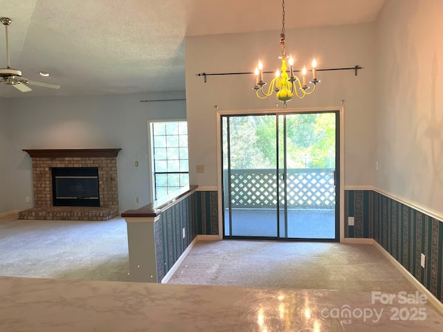 5810 Harris Grove Ln, Charlotte, NC 28212 - unfurnished dining area featuring a textured ceiling, wainscoting, ceiling fan with notable chandelier, a brick fireplace, and carpet floors